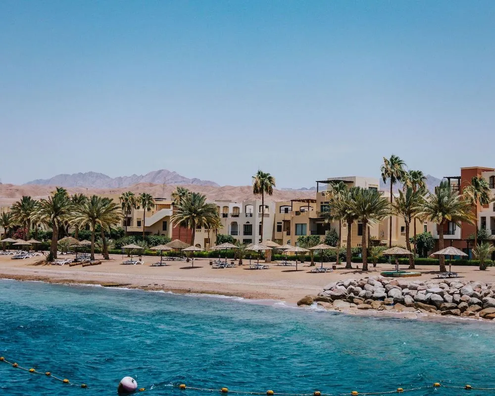 Seaside view of a luxury hotel resort lined with palm trees on the shores of Aqaba, Jordan.